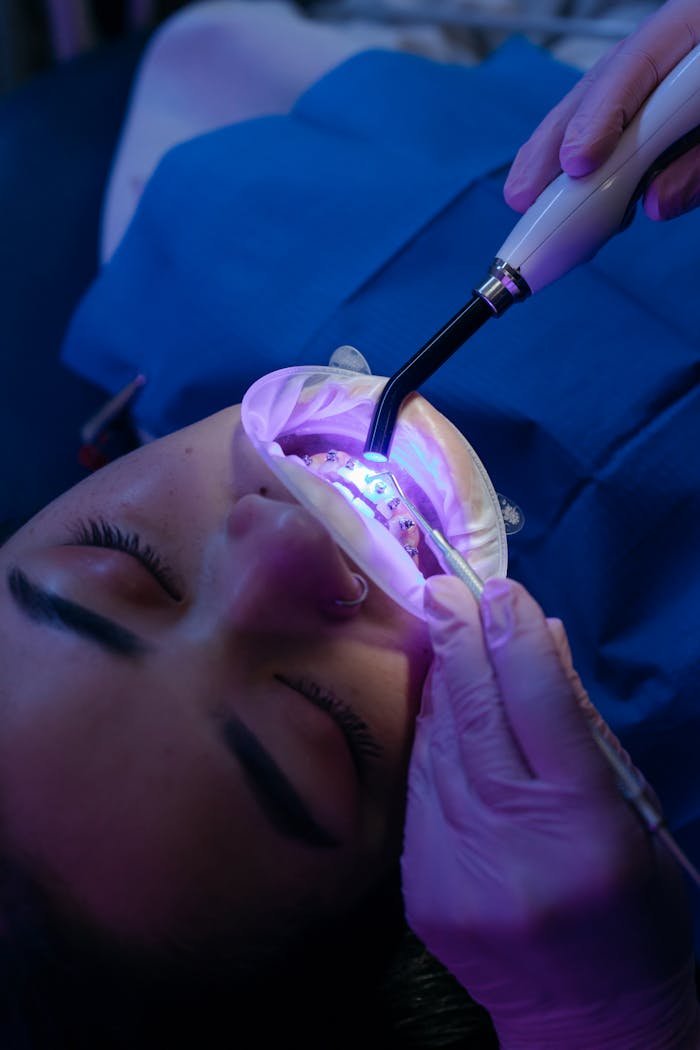 Close-up of a dental procedure with UV light treatment in a clinic.